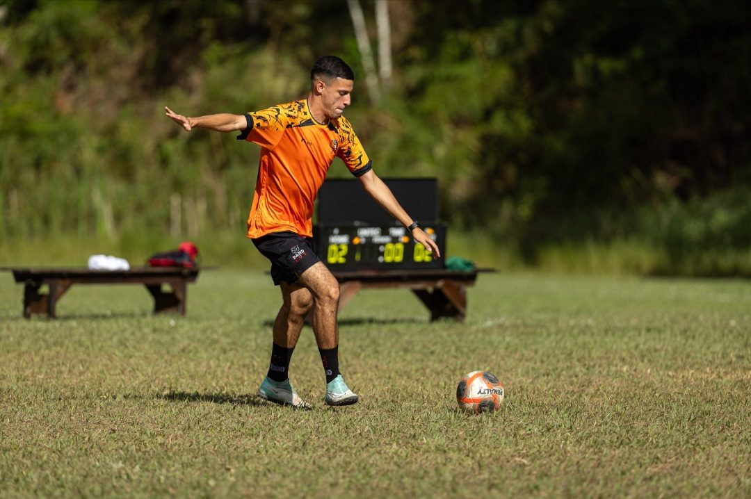 Professor Andre chutando a bola no campo