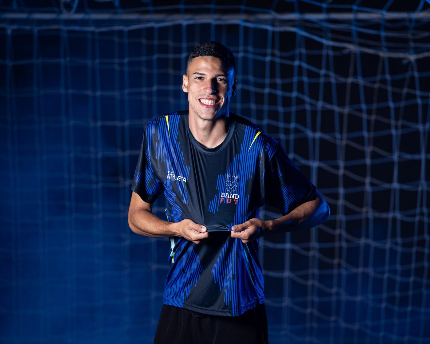 Professor Andre sorrindo em frente a uma rede de gol
